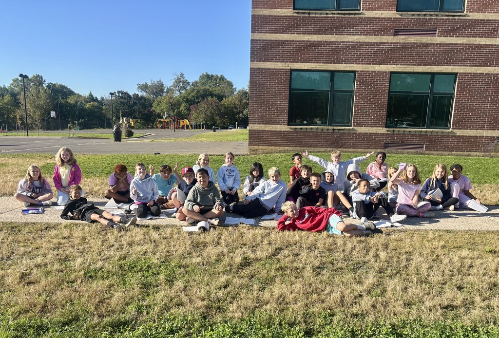 fourth graders sitting outside on a sensory walk