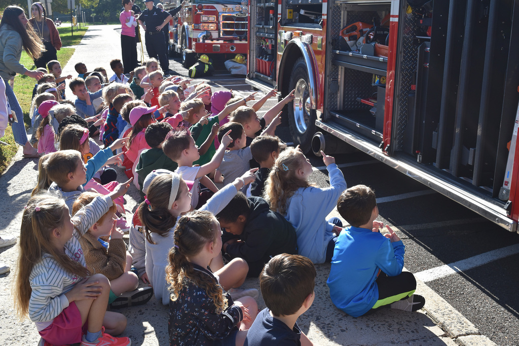 Copper Beech kindergarteners raise their hands to point to the equipment on the fire truck