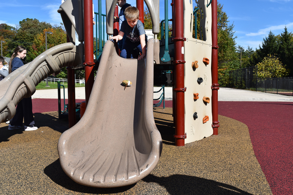 A second grader sends his potato down the slide in a race