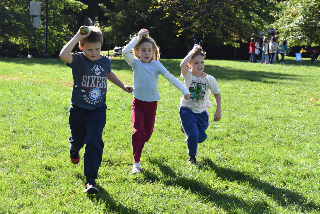 Second graders hold their potato athletes above their heads in an Olympic competition
