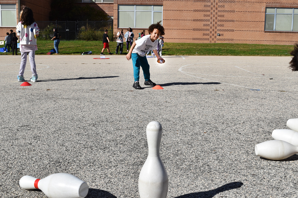 A second grade student bowls with his potato athlete