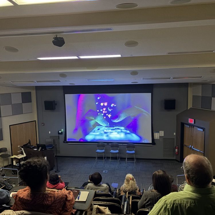 Attendees sit in a lecture hall to view the documentary