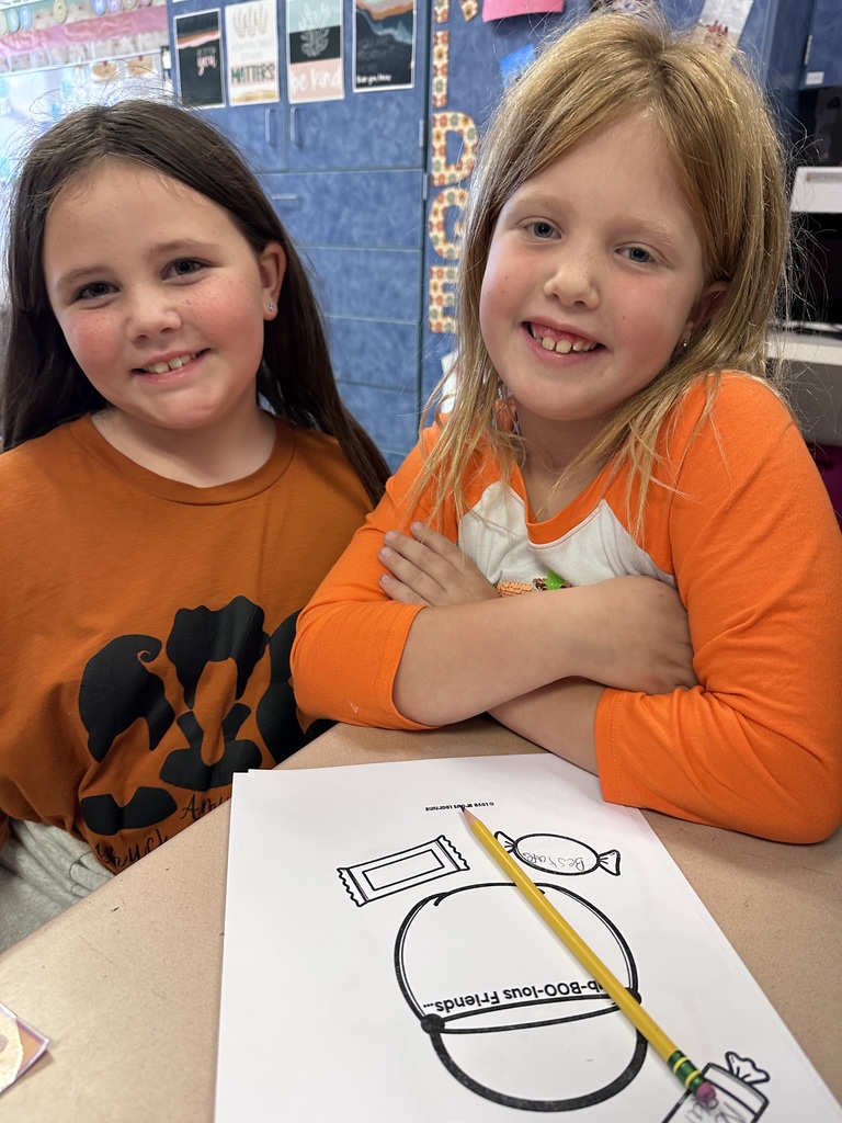 A Roslyn first grade and her third grade buddy student work on craft about being a buddy, not a bully