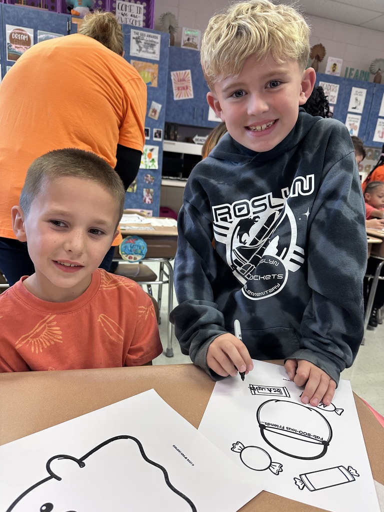 A Roslyn first grade and his third grade buddy student work on craft together
