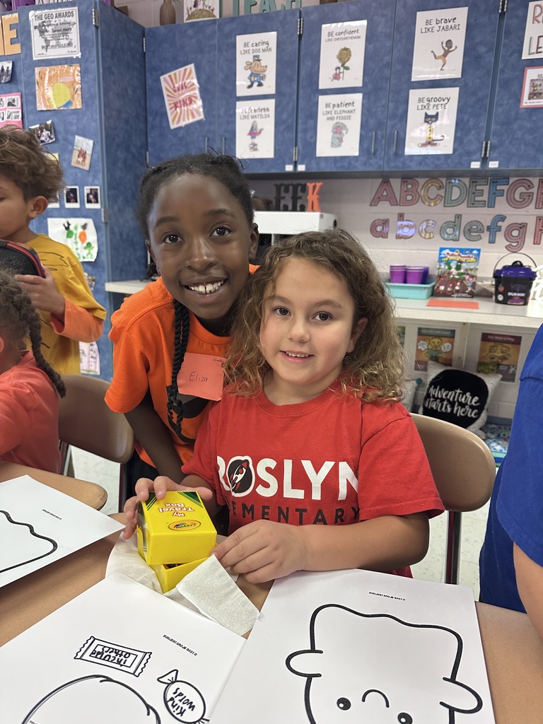 A Roslyn first grade and her third grade buddy student work on craft together