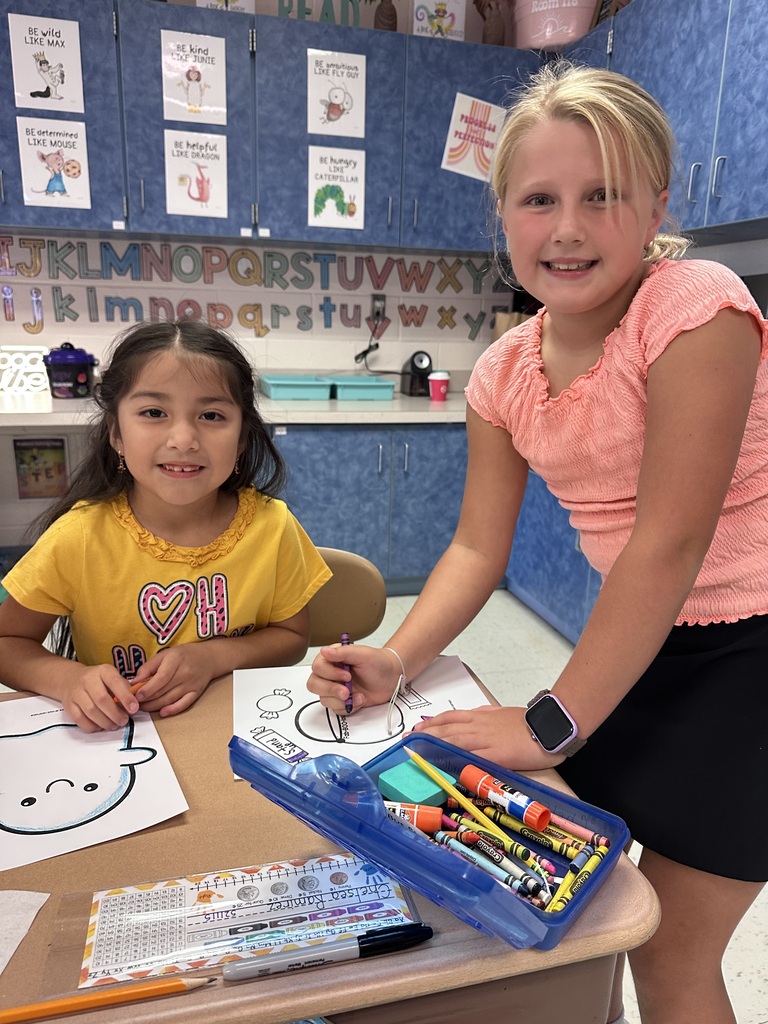 A Roslyn first grade and her third grade buddy student work on craft together