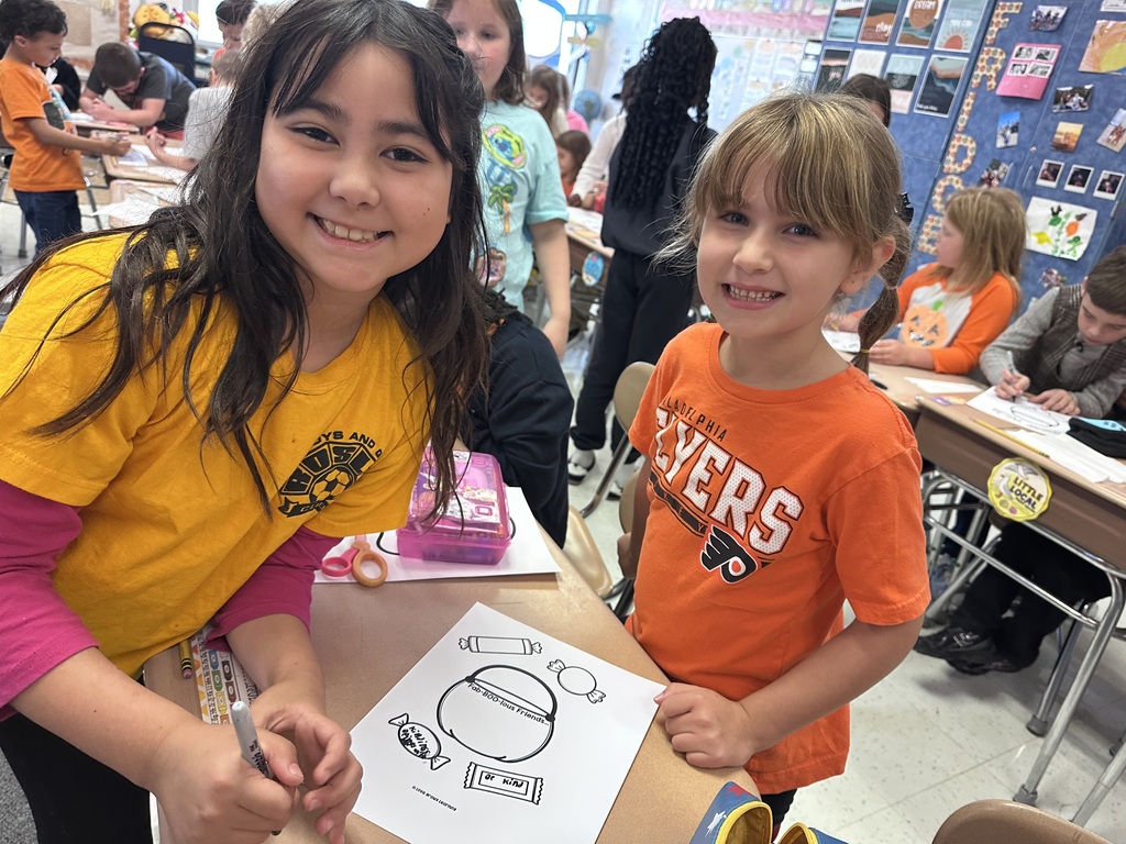 A Roslyn first grade and her third grade buddy student work on craft about being a buddy, not a bully