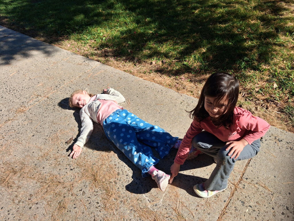 Students chalk outlining their bodies