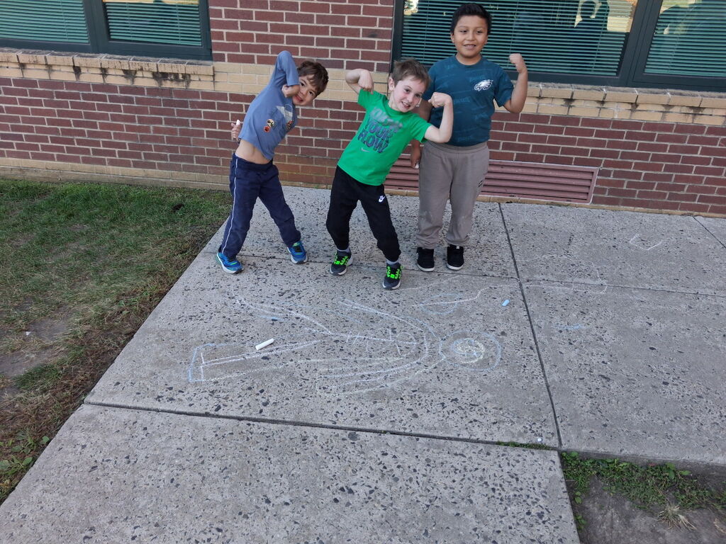 students smiling and showing their muscles