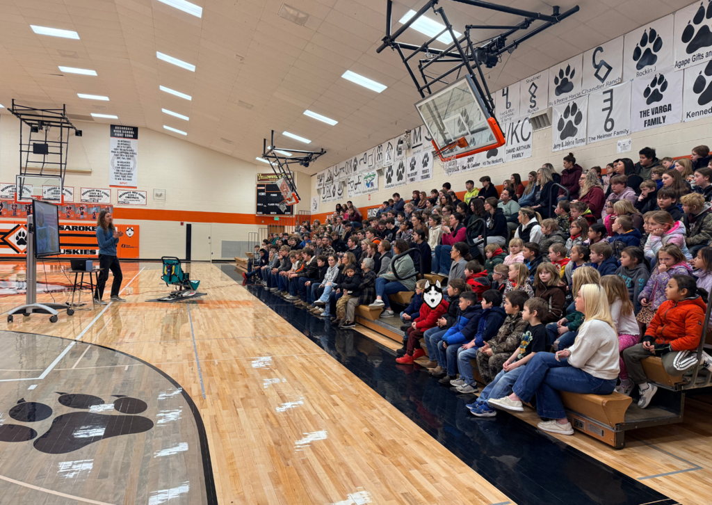 student sitting in bleachers listening to presenter