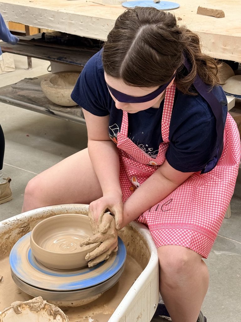 Blindfolded students throwing on a pottery wheel