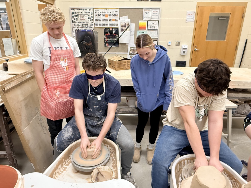 Blindfolded students throwing on a pottery wheel
