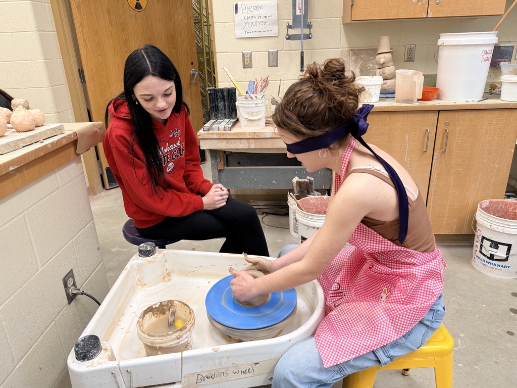 Blindfolded students throwing on a pottery wheel