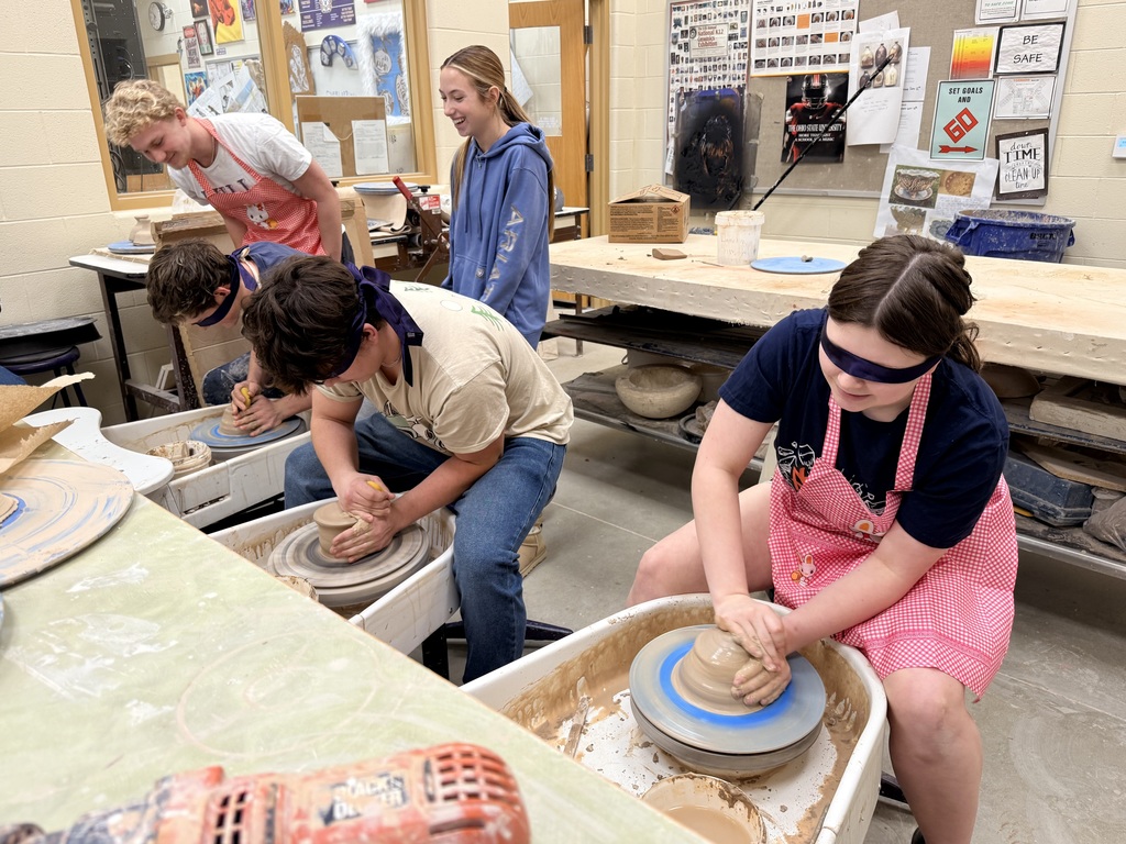 Blindfolded students throwing on a pottery wheel