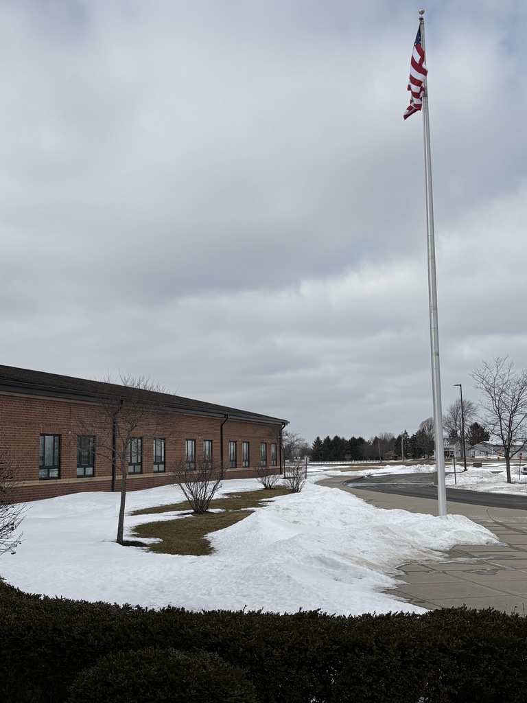 Front of school with flag pole and snow