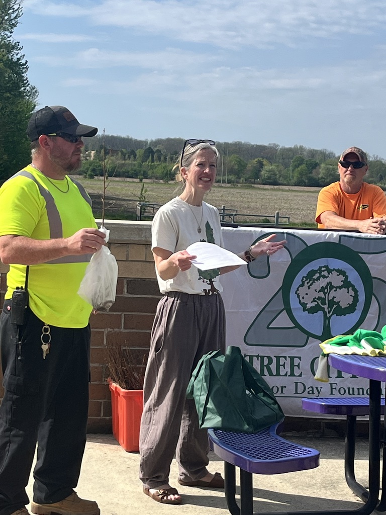 women speaking to a crowd with two men on the sides standing by