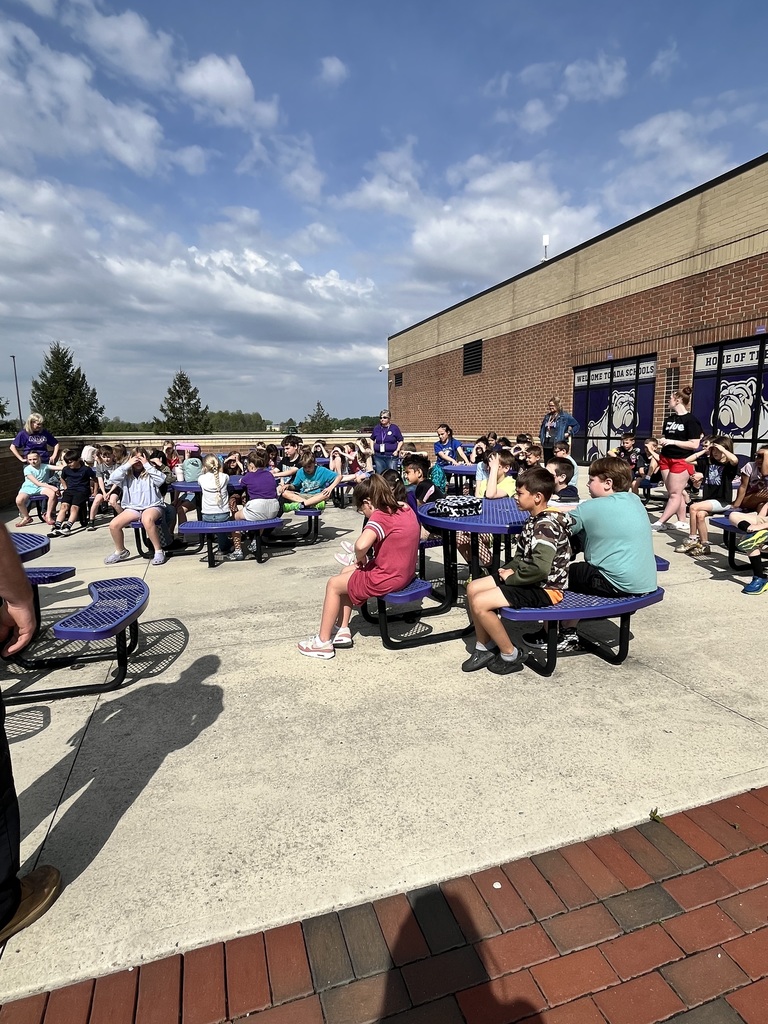 students sitting at tables listening to a presenter