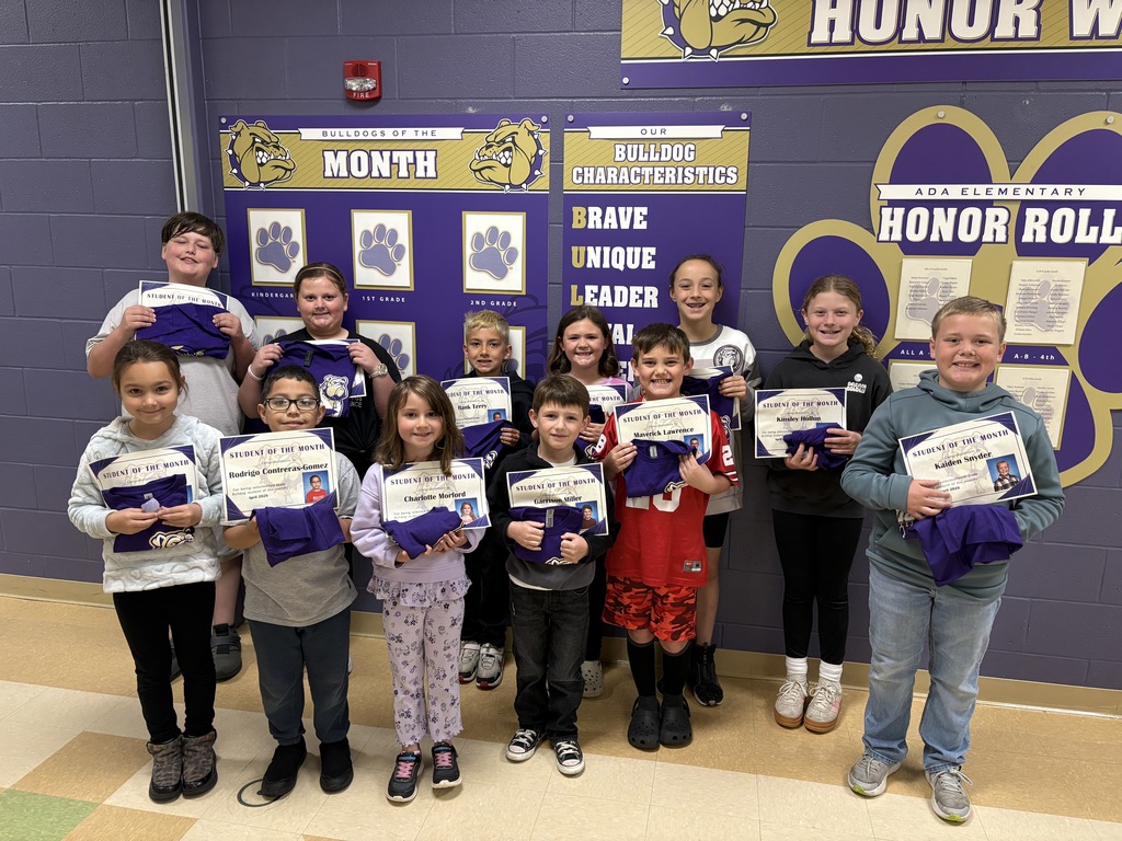 Twelve students standing in front of wall graphics holding certificates 