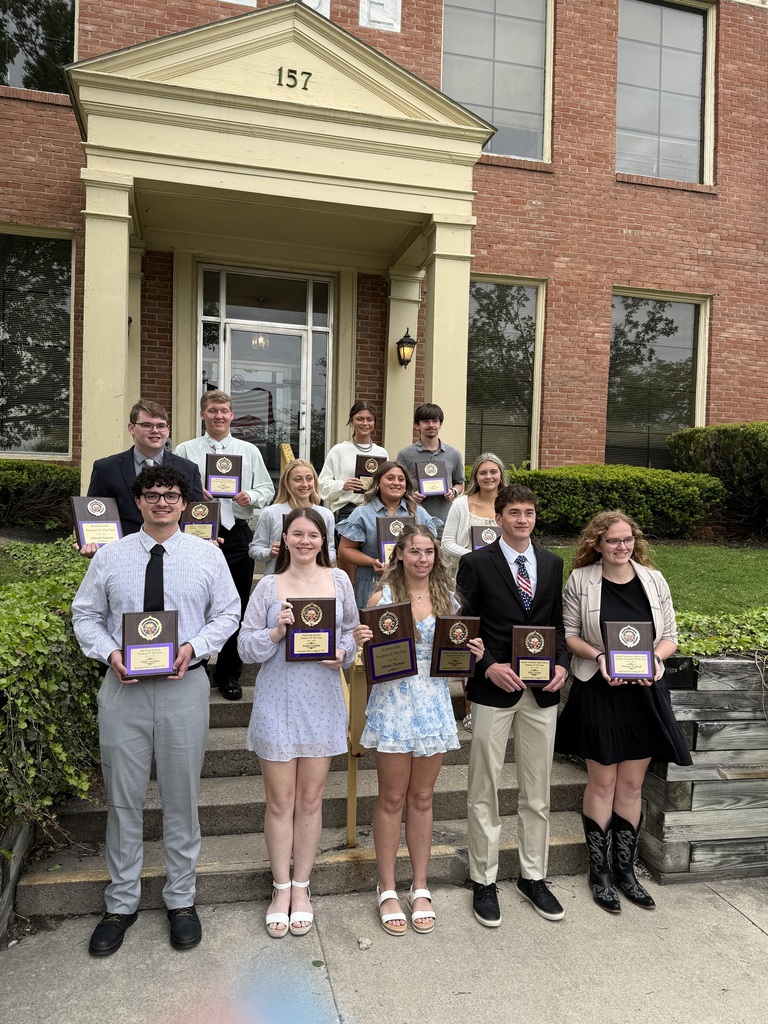 12 students holding plaques in front of the Elk lodge