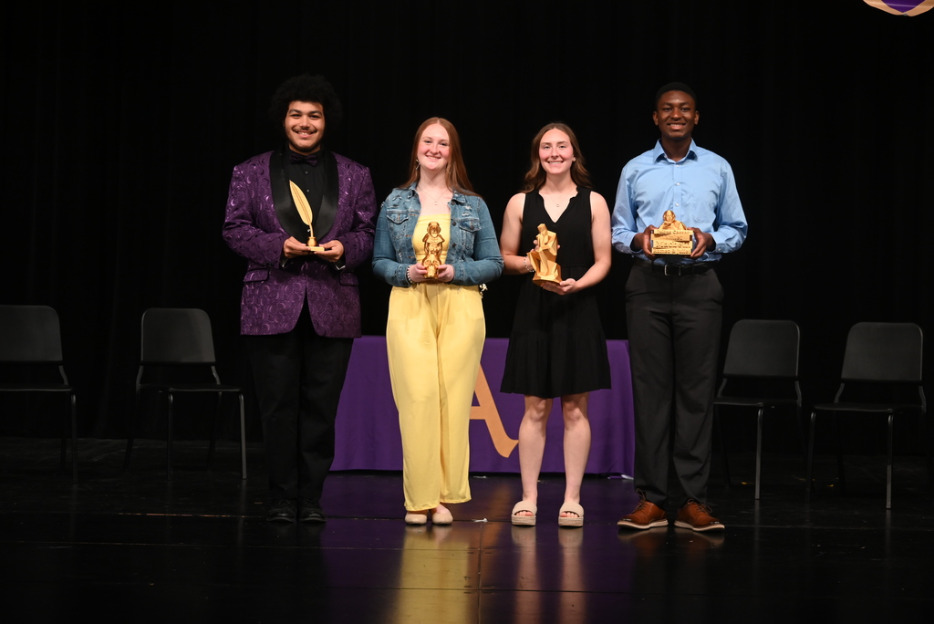 Four students holding trophies 