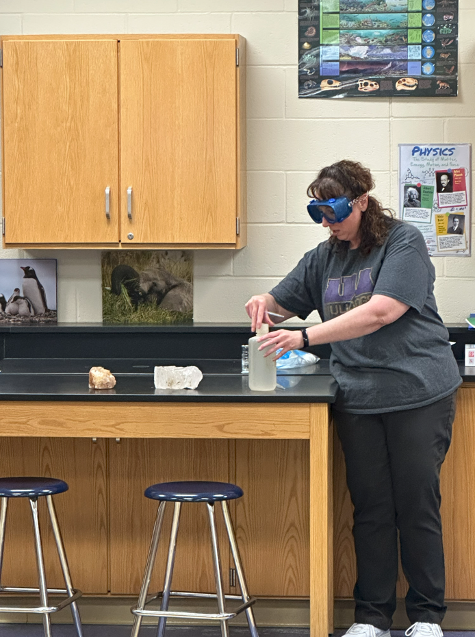 3rd grade students sitting at lab tables learning from high school students