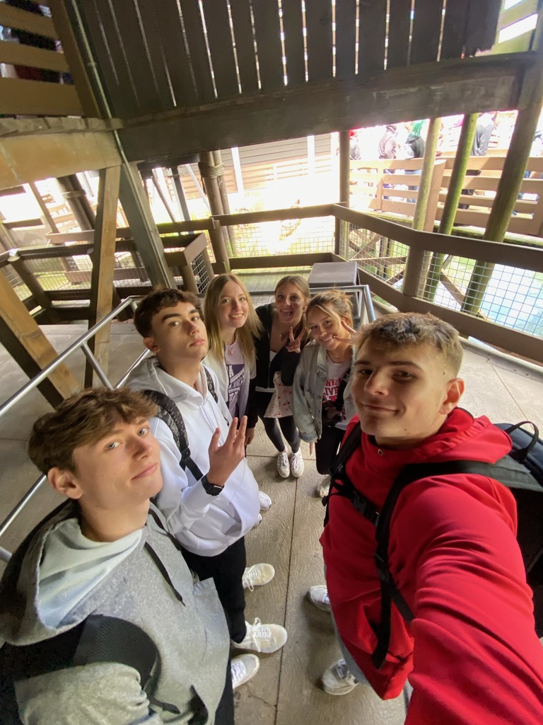 Six students waiting in line for a roller coaster