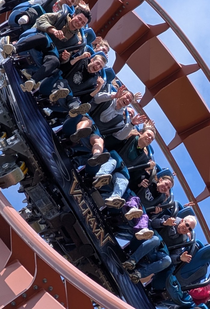 Students on a roller-coaster with hands raised in the air