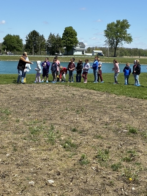 Students walking in the dirt planting seeds