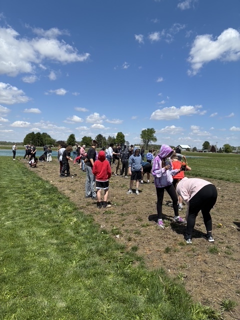 Students walking in the dirt planting seeds
