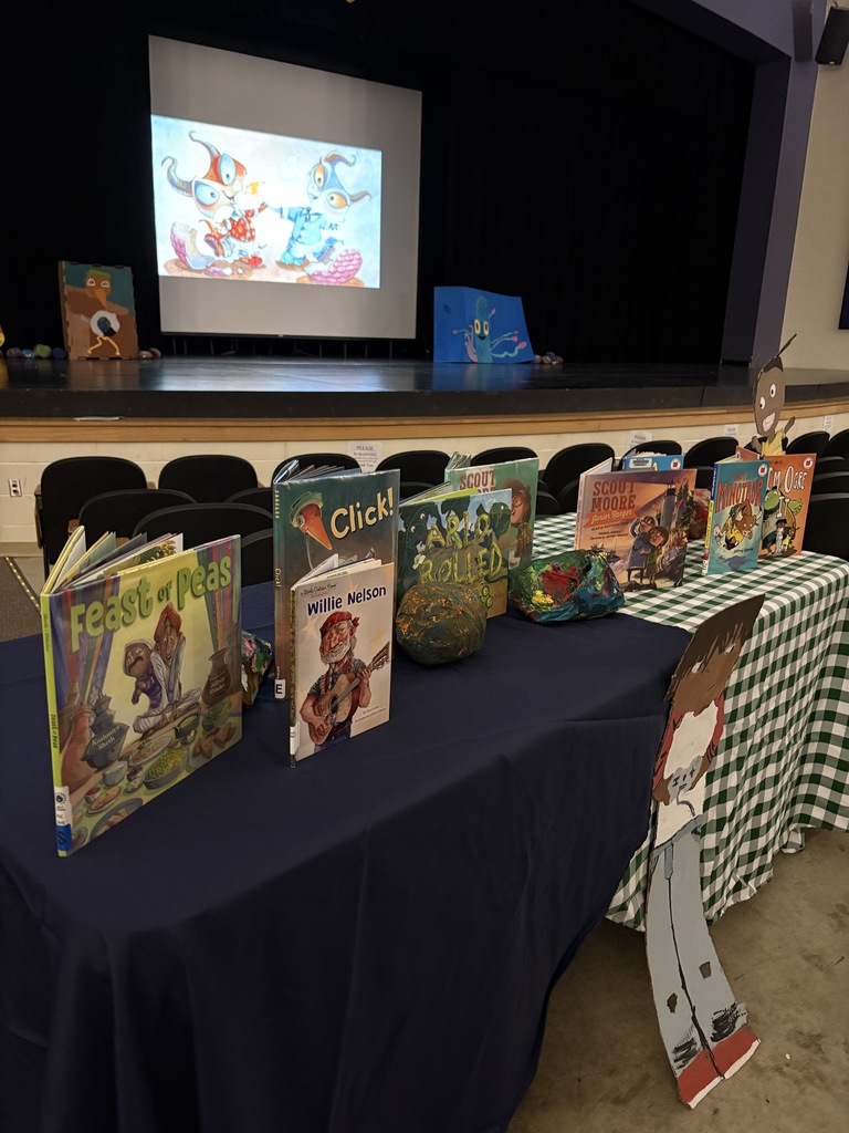 Table with books displayed and projector in the background