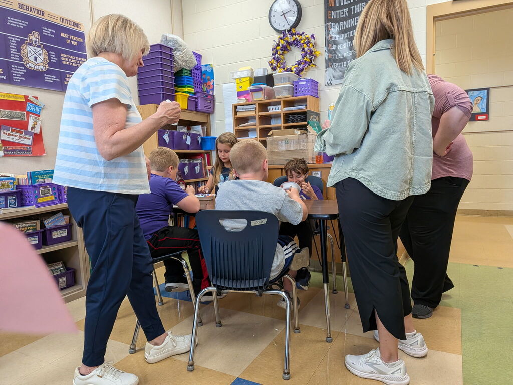 First grade students sitting around a table eating ice cream