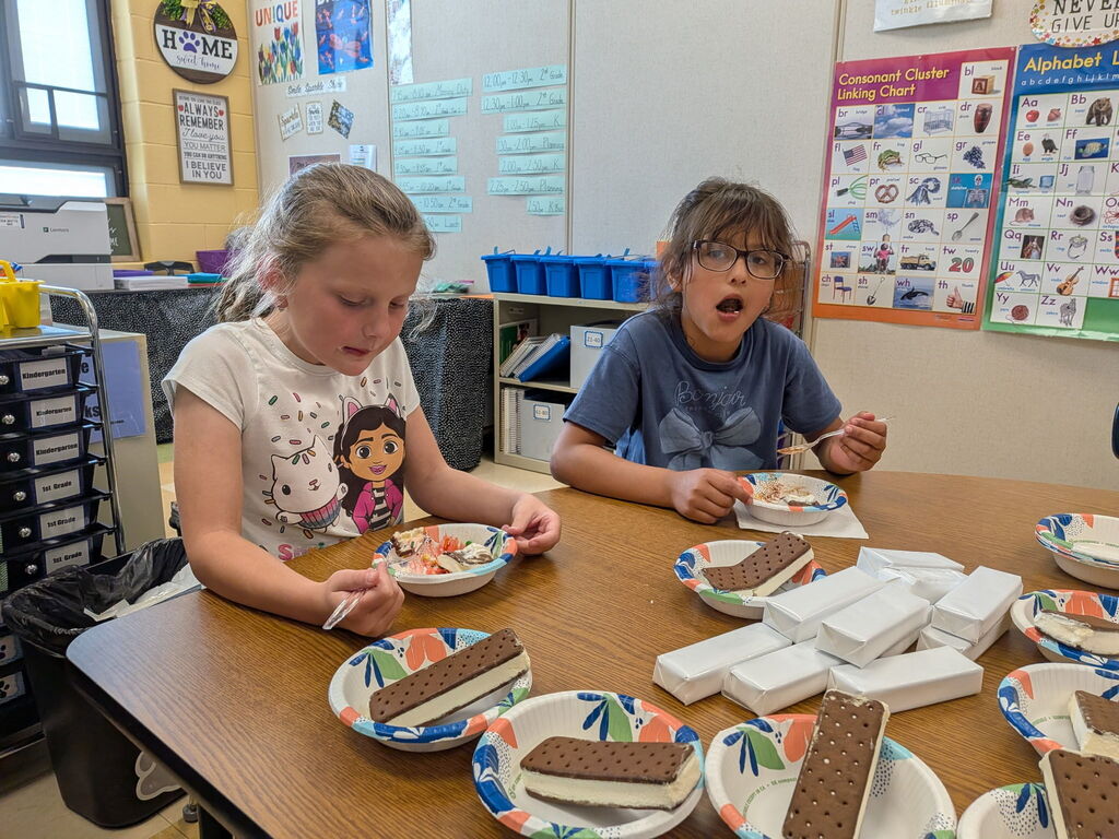 First grade students sitting around a table eating ice cream