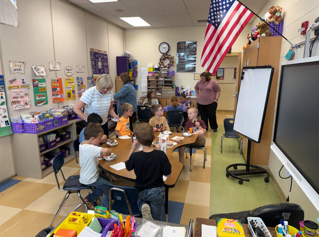 First grade students sitting around a table eating ice cream