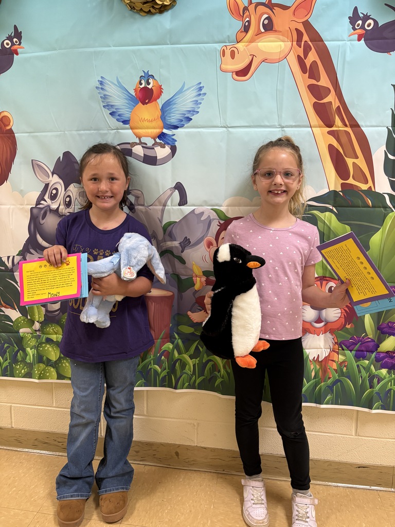 Two students holding stuffed animals smiling with certificates
