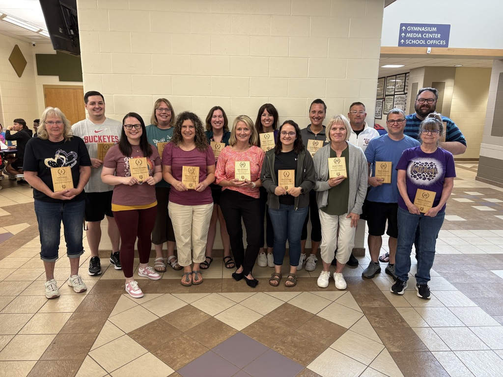 15 adults standing holding plaques