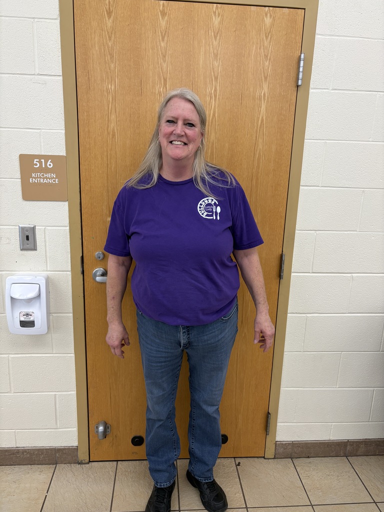 Women standing in purple shirt with a smile