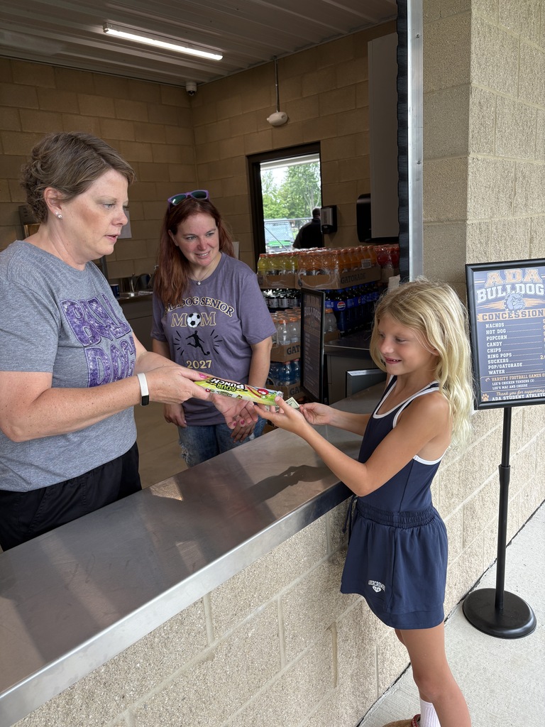Little girl paying for candy at the counter of the concession stand