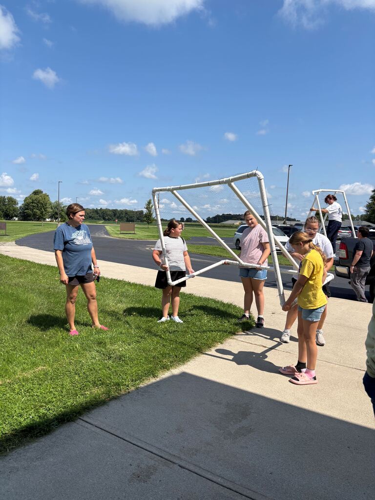 Four students carrying a soccer net