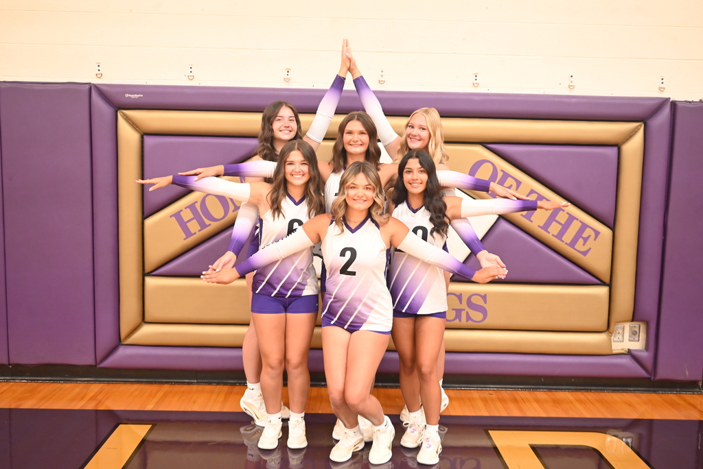 Six volleyball students standing with their arms in a star shape