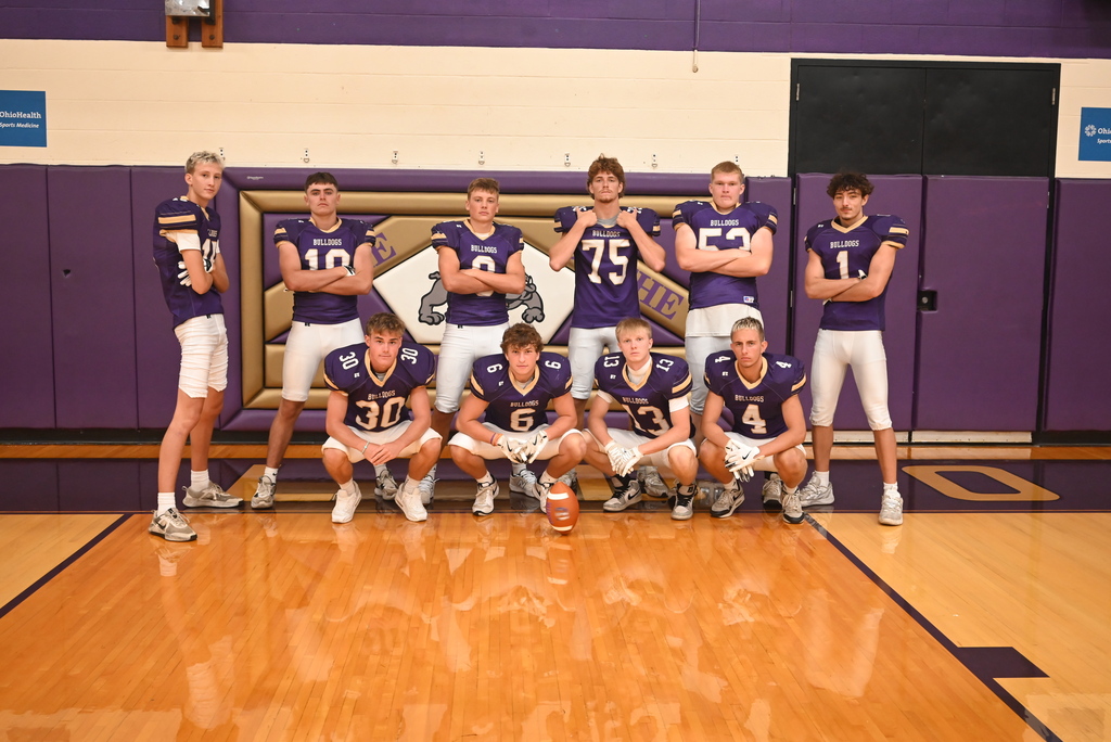 10 student football players standing in two rows