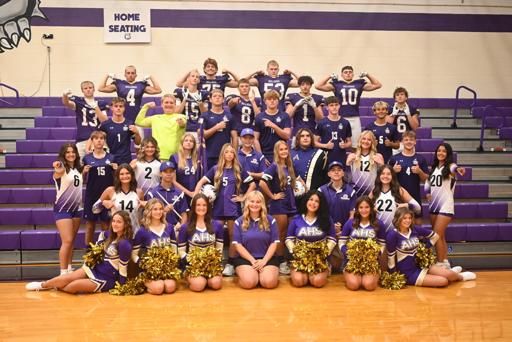 A large group of students in a pyramid smiling at the camera