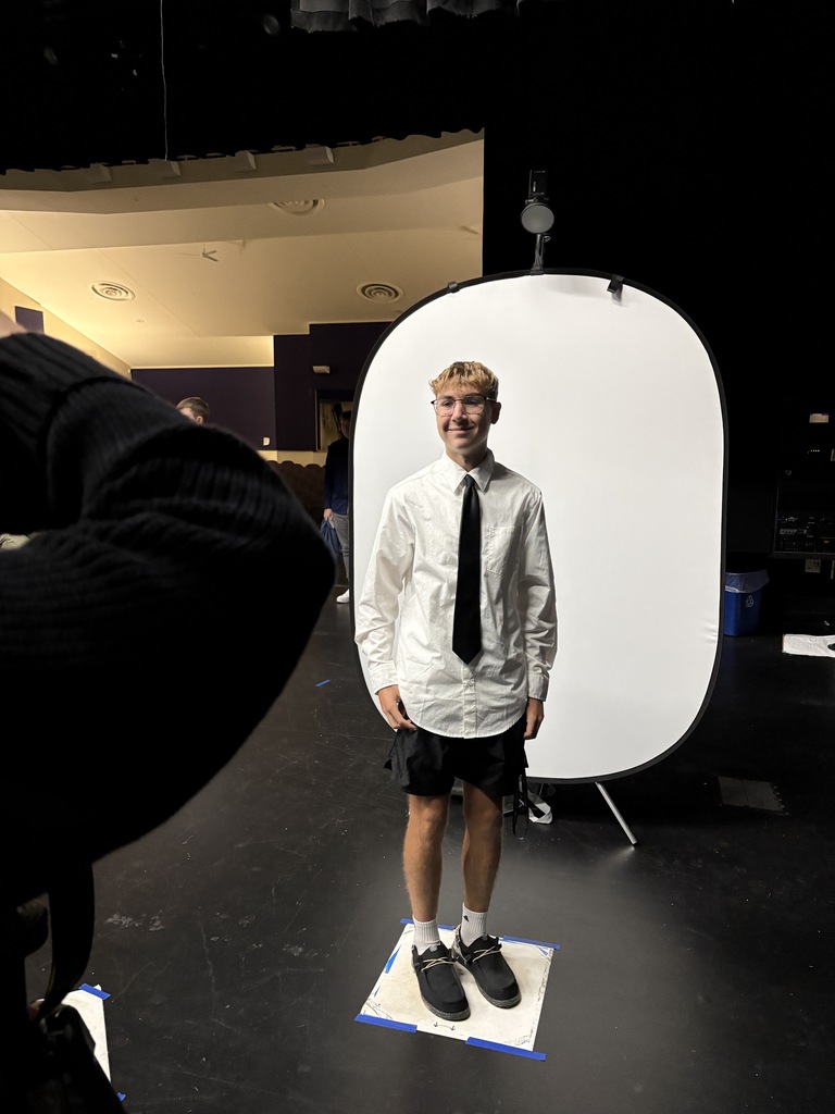 male student in white shirt standing in front of white background