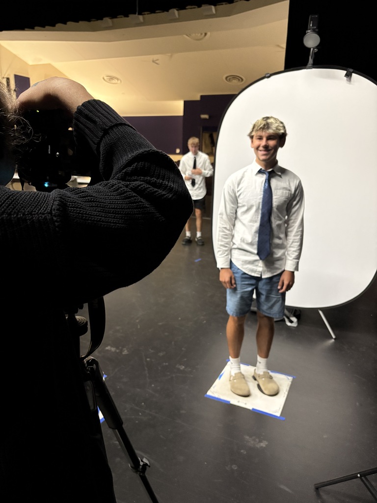 male student in white shirt standing in front of white background