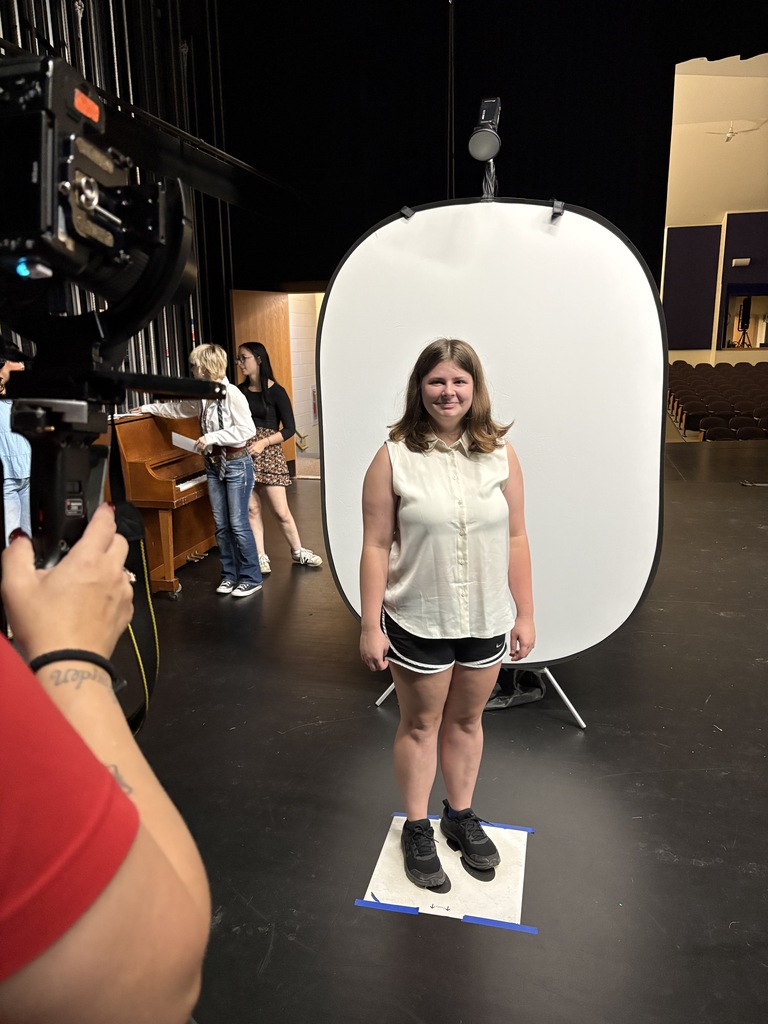 female student in white shirt standing in front of white background