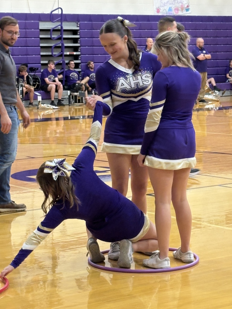 High school students standing in hula hoops on a gym floor