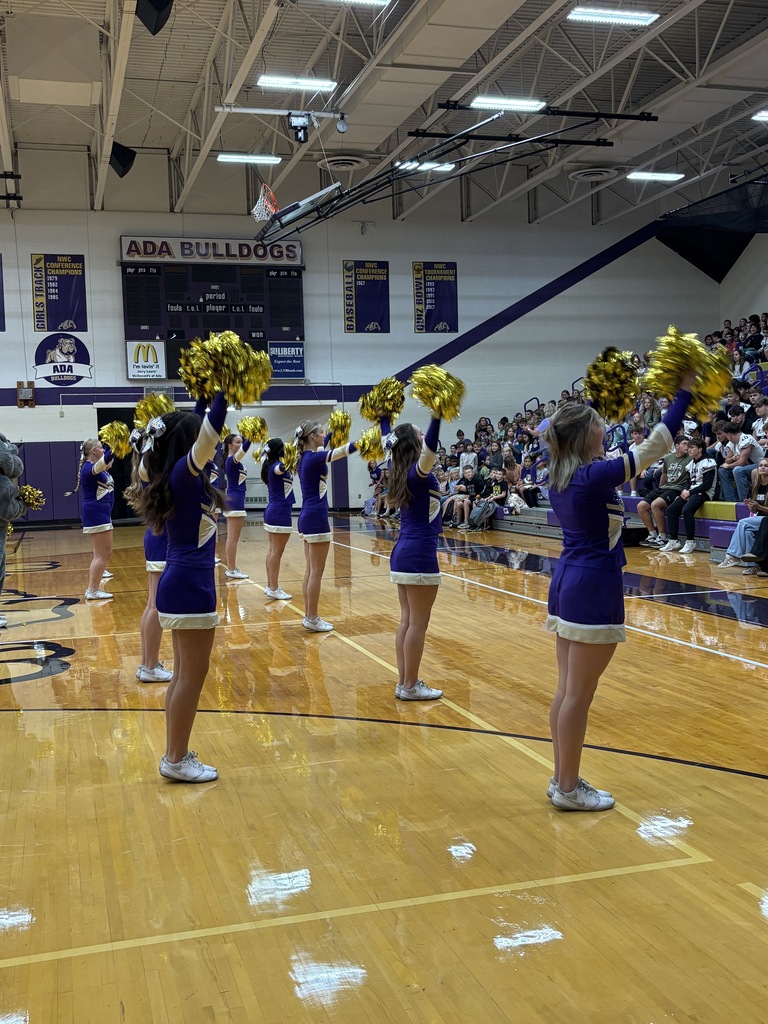 cheerleaders with gold pom poms on the gym floor