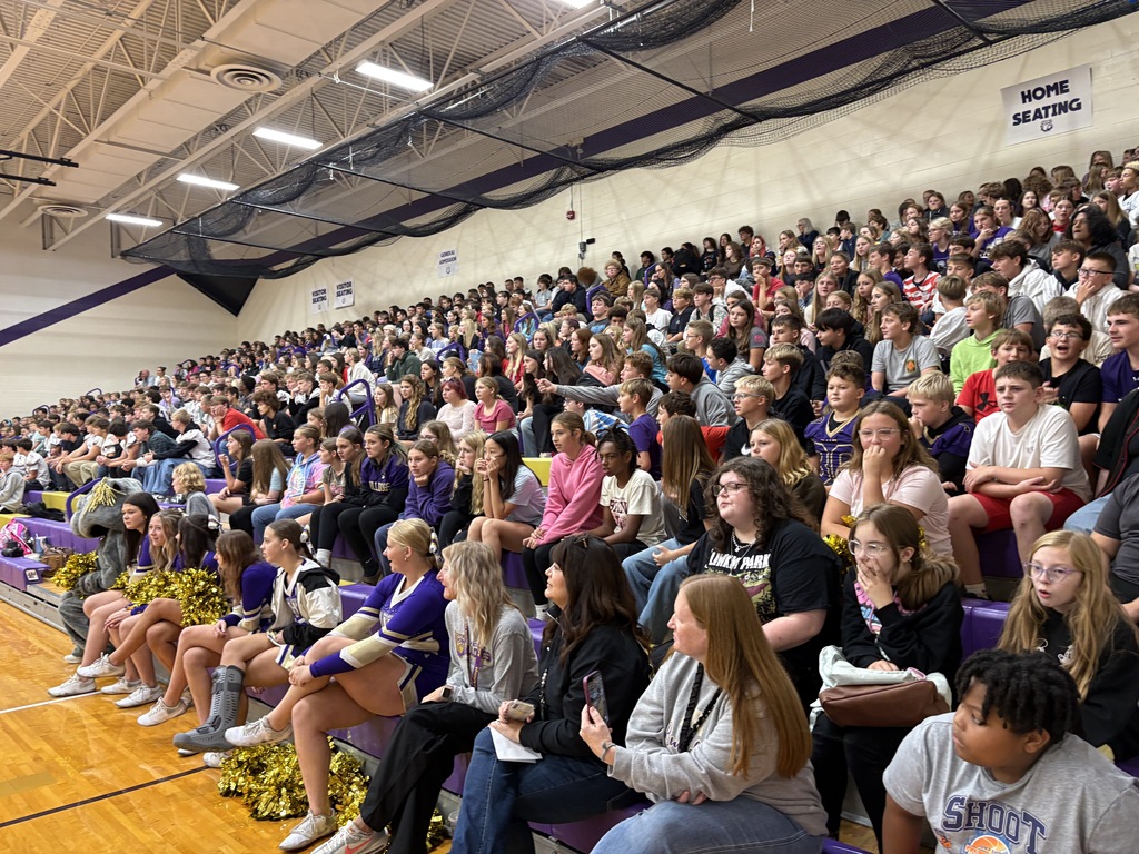 students sitting in gymnasium bleachers