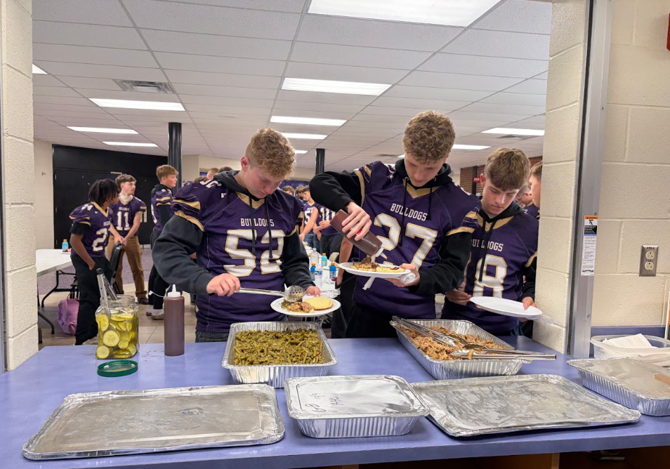 male football players filling white plates with food