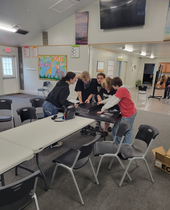 students gathered around a tv fixing a mount