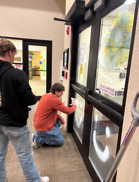 two male student cleaning windows